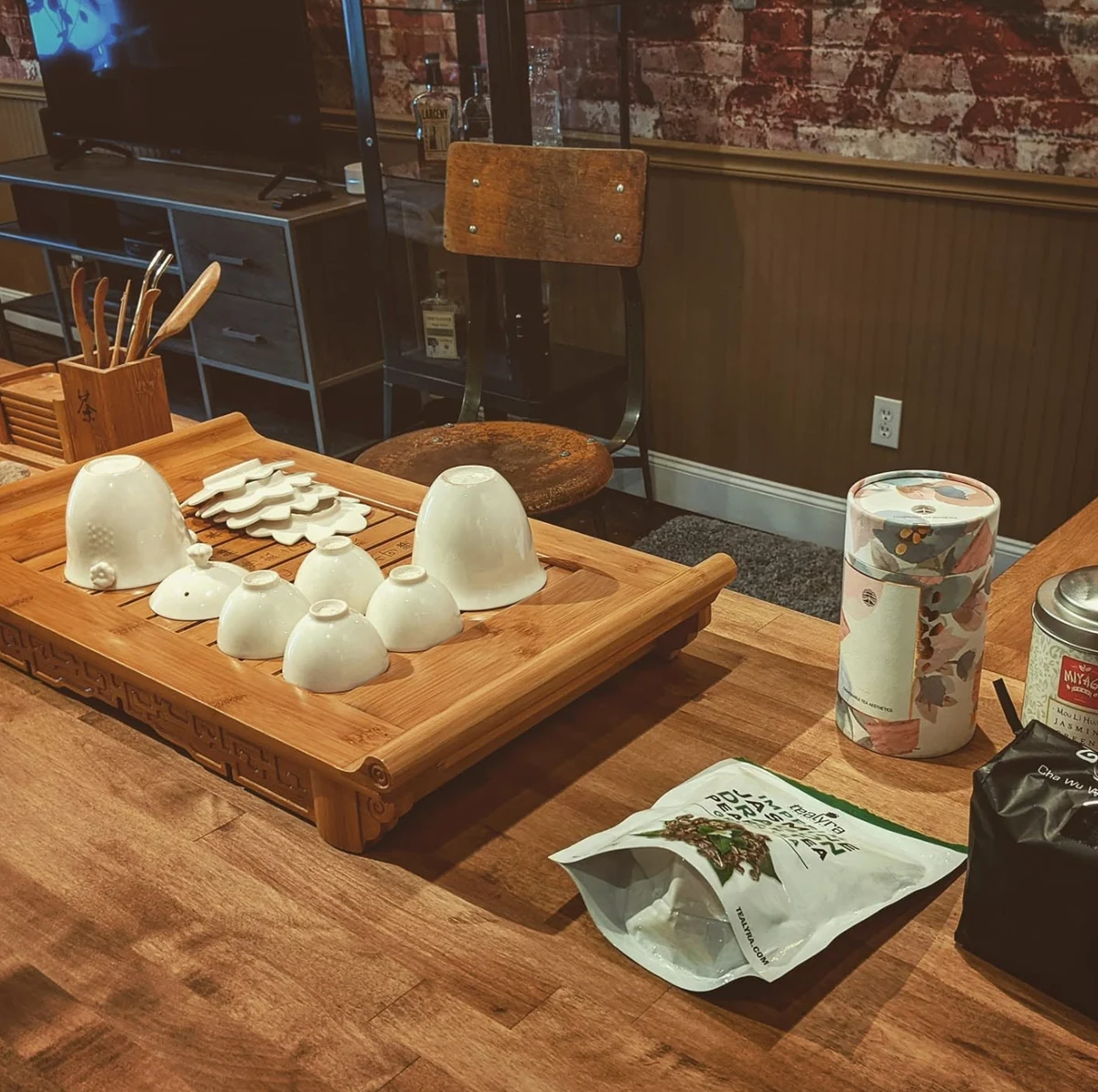 Tea cups and tea equipment arranged on a wooden tray and table