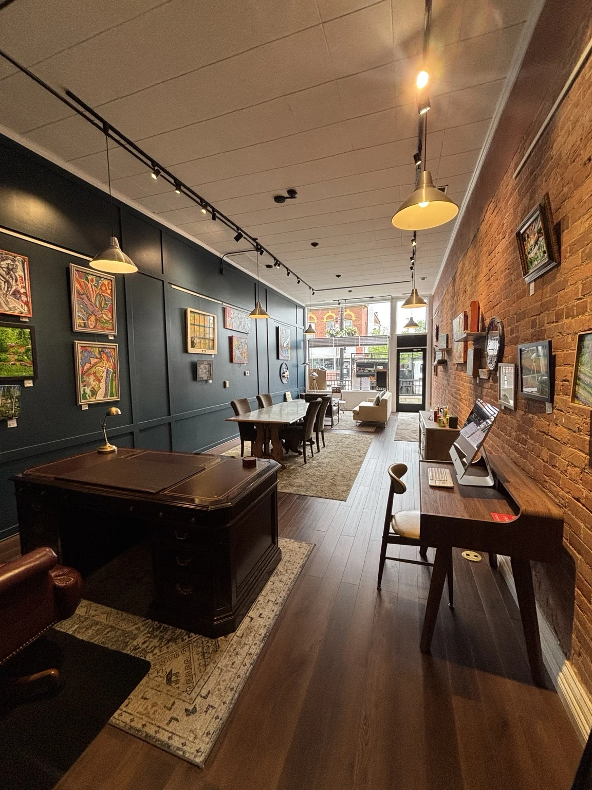 Spacesicle’s Main Street interior, with artwork, exposed brick, a meeting table and work desks.